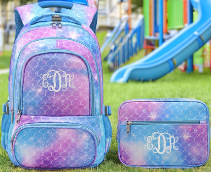 Backpack and lunchbox set with blue and purple mermaid scales and white EDH monogram.