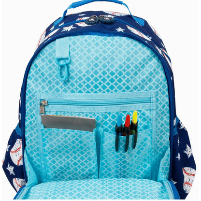Open backpack with baseball pattern, light blue interior, and pockets holding pens and a notebook.