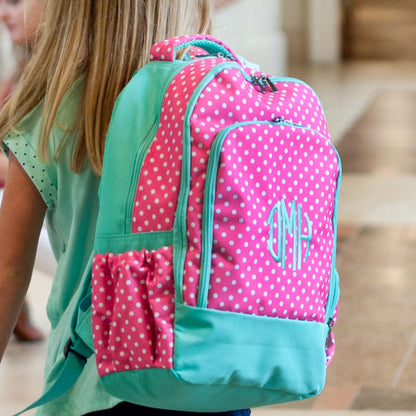Child wearing a pink Dottie backpack with a mint monogram