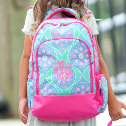Child holding a Marlee patterned backpack in front of the body