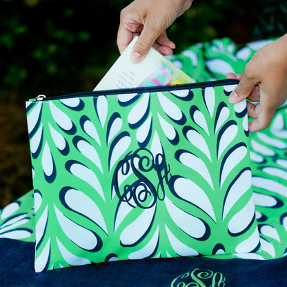 Green and white leaf-print pouch with a navy monogram