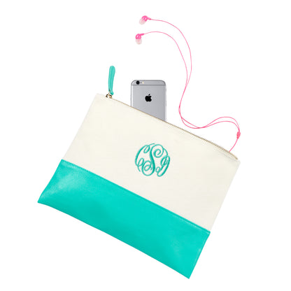 Mint color-block pouch with a monogram, phone and earbuds