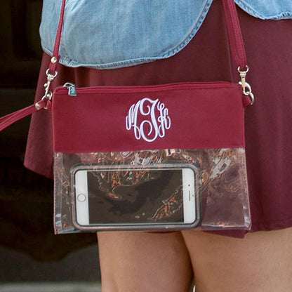 Clear bag with garnet trim, monogram close-up with a phone inside