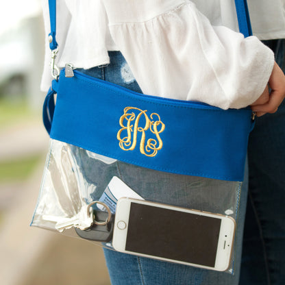 Clear bag with royal blue trim, monogram close-up with a phone inside