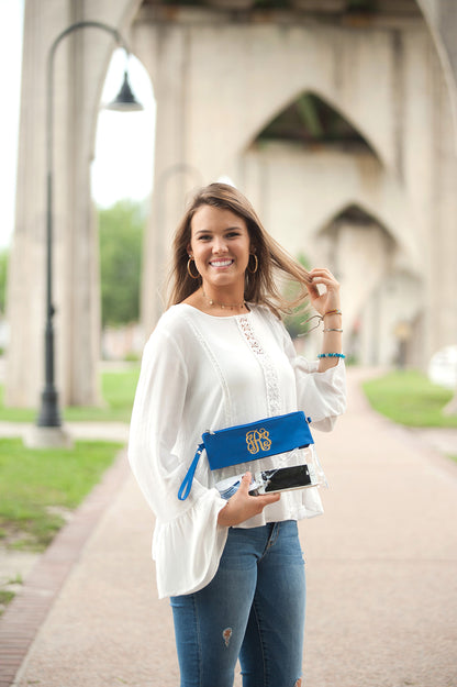 Clear bag with royal blue trim, held in front of the body