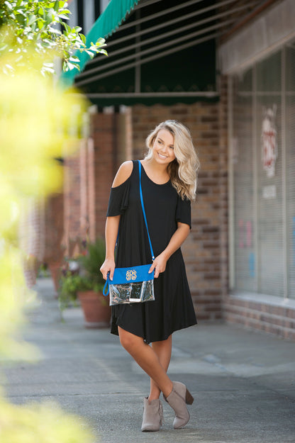Clear bag with royal blue trim, worn as a crossbody bag outdoors