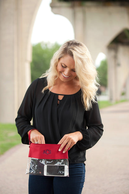 Clear bag with red trim, held at the waist