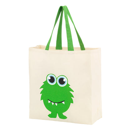 Cream canvas tote with a fluffy green monster face, big blue eyes, toothy smile, and green handles, three quarter view on white