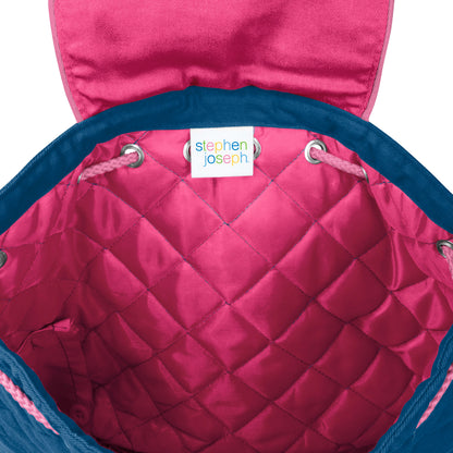 Pink quilted Stephen Joseph backpack interior with blue trim, drawstring closure, and white brand label stitched inside the diamond-quilted lining