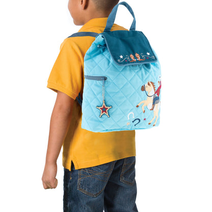Toddler wears quilted blue Stephen Joseph cowboy backpack with embroidered horse rider, star charm, and Western-themed print on back