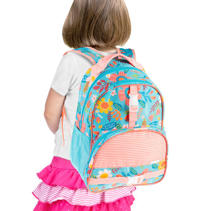 Young girl wearing turquoise Stephen Joseph backpack with colorful all-over floral print, pink straps, and striped front pocket against white background