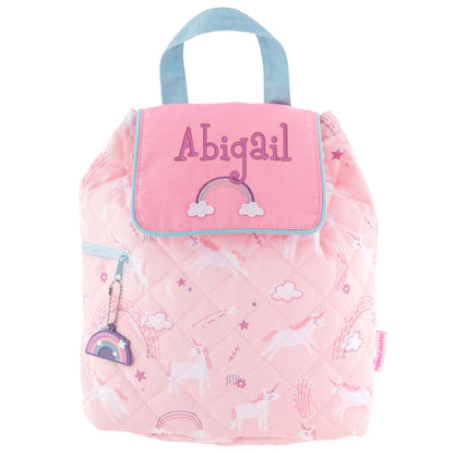 Pink quilted kids’ backpack with rainbow print, blue trim, embroidered name, and rainbow zipper charm.