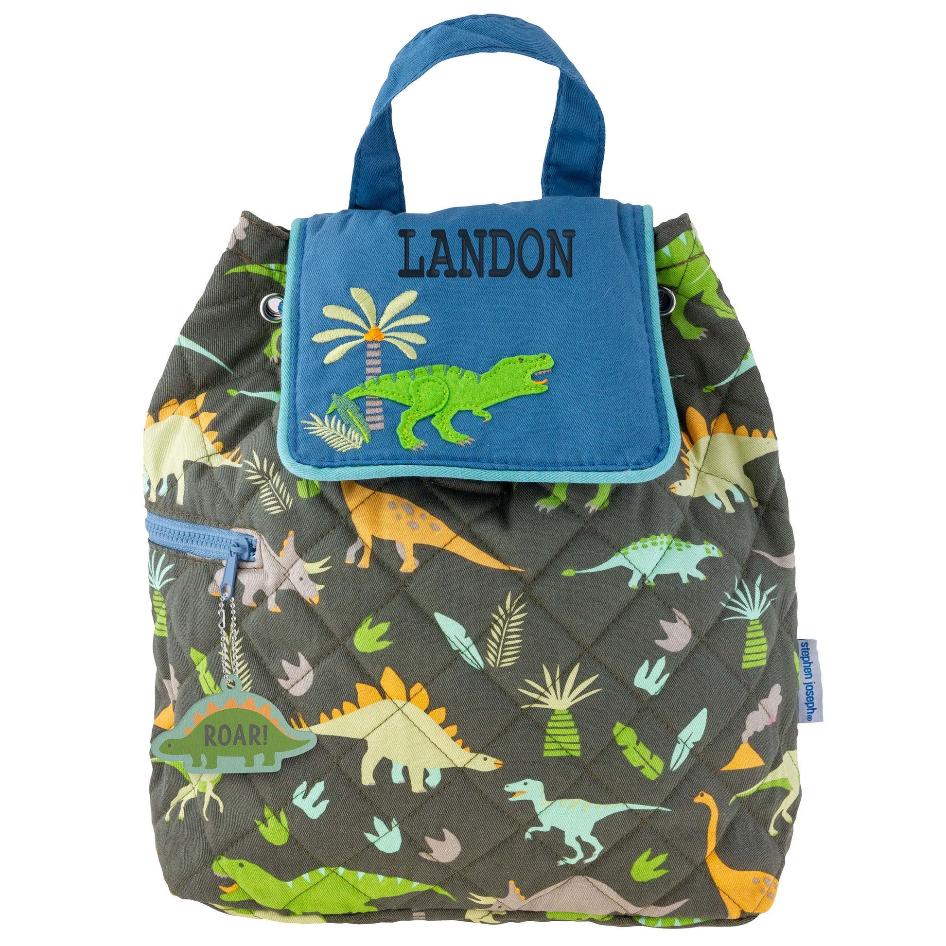 Quilted charcoal backpack with colorful dinosaur print, blue flap, green alligator appliqué, and top handle.