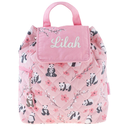 Pink quilted backpack with panda and floral print, top handle, name flap, side zipper, and panda charm.