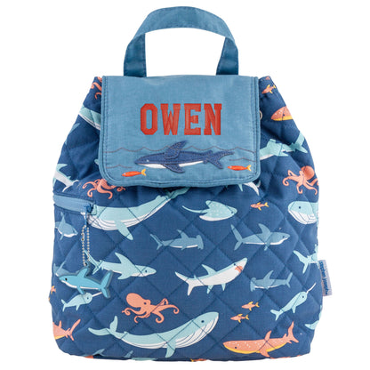 Quilted navy backpack with colorful sea animals, light blue flap, shark zipper charm, and red OWEN embroidery
