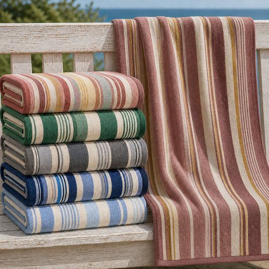 Sunwash and Seashore striped beach towel color options displayed on a coastal bench