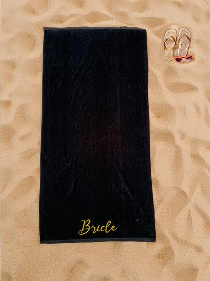 Black velour beach towel with gold Bride embroidery on sand