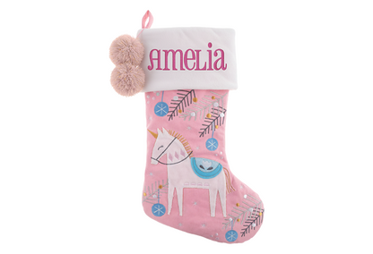 Pink unicorn stocking with white cuff, embroidered name Amelia, and pom-poms.