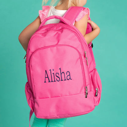 Child holding a hot pink backpack embroidered with Alisha