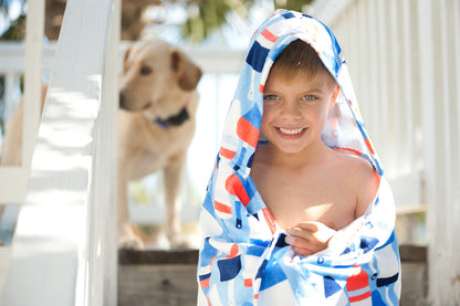Smiling child wrapped in an Oh Buoy hooded towel