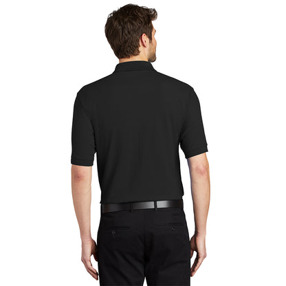 Back view of a man wearing a plain black short-sleeved polo shirt with a collar and black pants.