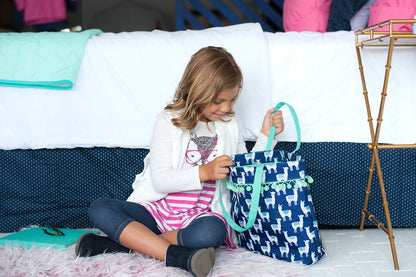 Child holding a navy llama tote while reading
