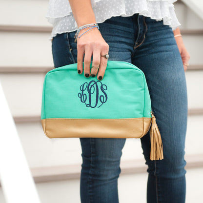 Mint Cabana cosmetic bag with navy monogram carried by hand