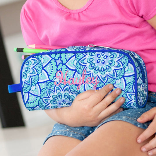 Close-up of embroidered Hayley personalization on a blue mandala pencil case held in a child's lap