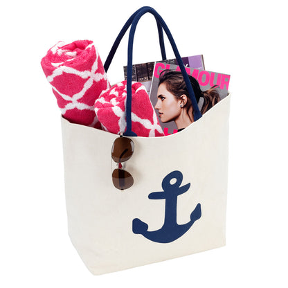 Navy anchor tote holding a towel and magazine with sunglasses at the edge