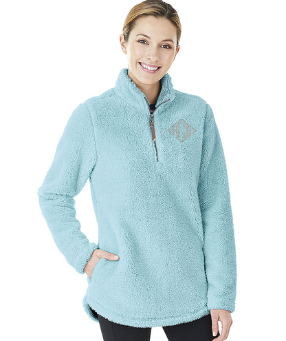 Woman wearing a light blue Charles River Newport fleece pullover with a quarter-zip and diamond monogram.
