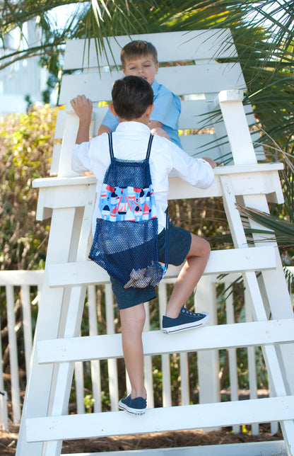 Child wearing a buoy-print mesh backpack while climbing a lifeguard chair