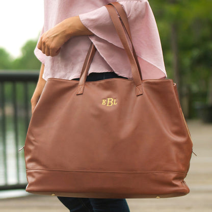 Camel Cambridge travel tote with gold-colored initials held at the waist