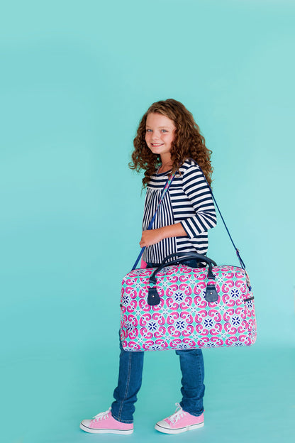 Child carrying a Mia tile-print duffel at the side