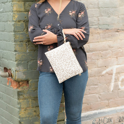 Woman wearing a cream leopard-print crossbody bag