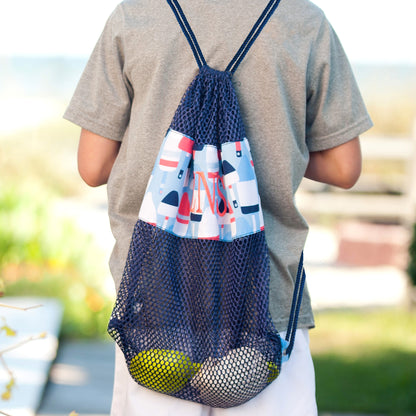 Back view of a child wearing a buoy-print mesh drawstring backpack