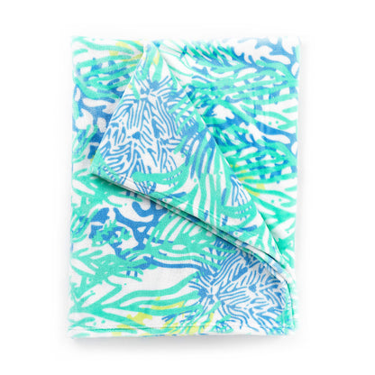 Folded blue and green tropical-print blanket