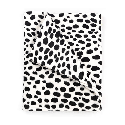 Folded white blanket with black animal spots