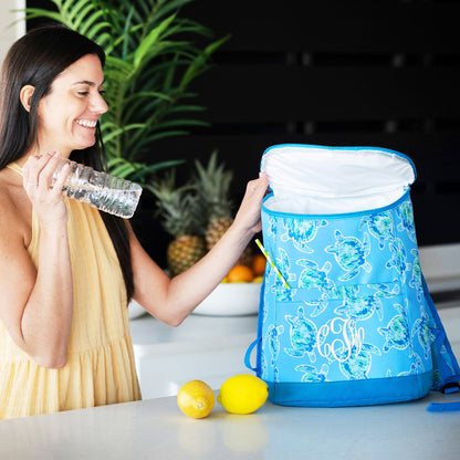 Woman beside an open blue turtle-print cooler backpack