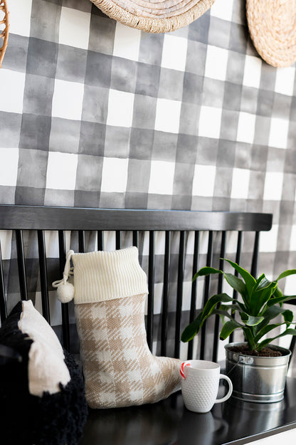 Tan and cream check knit stocking with cream cuff on a black bench