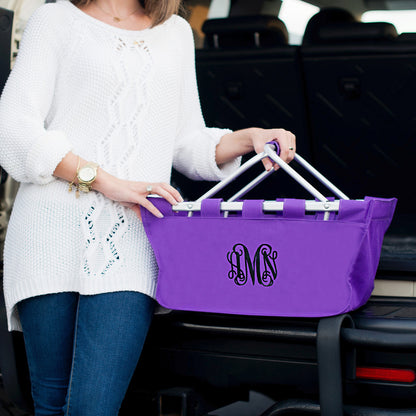 Woman holding a purple market basket with black monogram