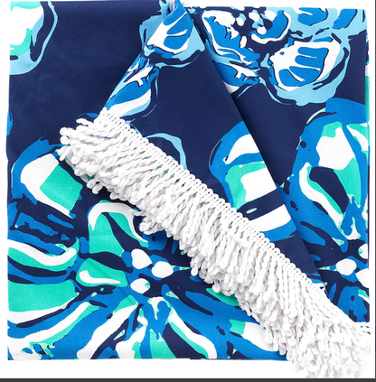 Close view of a blue floral blanket with white fringe