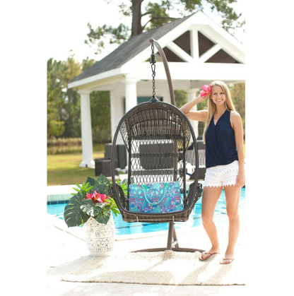 Blue patterned tote beside a woman near an outdoor hanging chair