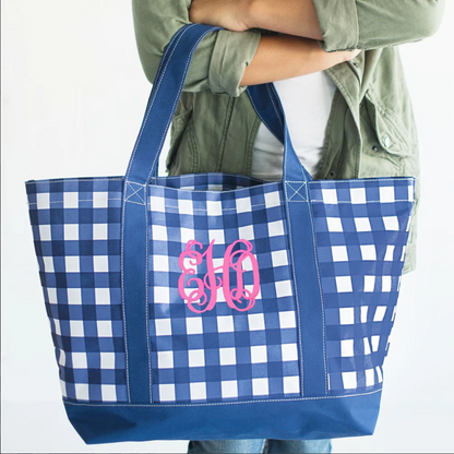 Navy checked tote with pink monogram carried by its handles