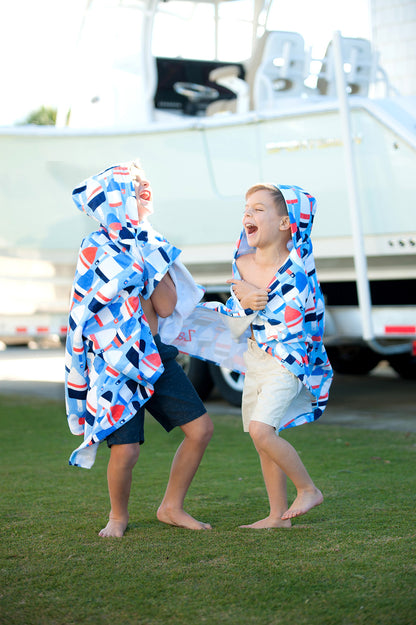 Two children outdoors wearing nautical hooded towels