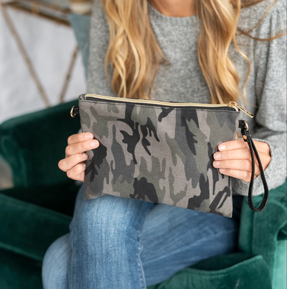 Woman holding a gray camouflage wristlet