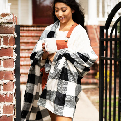 Woman wrapped in a black and white buffalo-check blanket