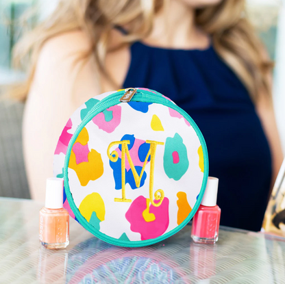 Multicolor animal-print jewelry case with a monogram beside nail polish