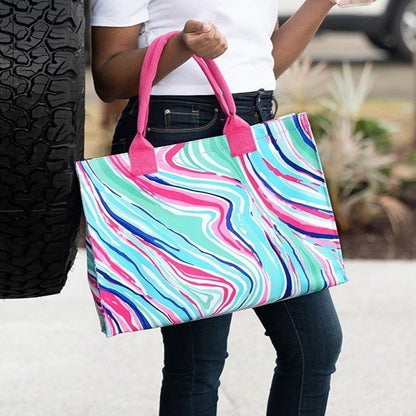 Woman carrying a colorful swirl-print tote with pink handles