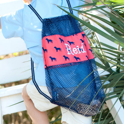 Navy mesh backpack with orange dog-print band embroidered with Reid