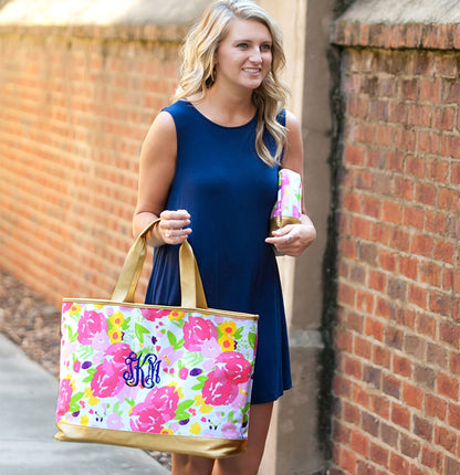 Woman carrying a personalized floral tote beside a brick wall